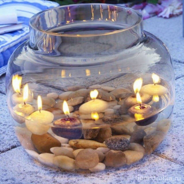 Круглые плавающие свечи в маленьком аквариуме с камнями