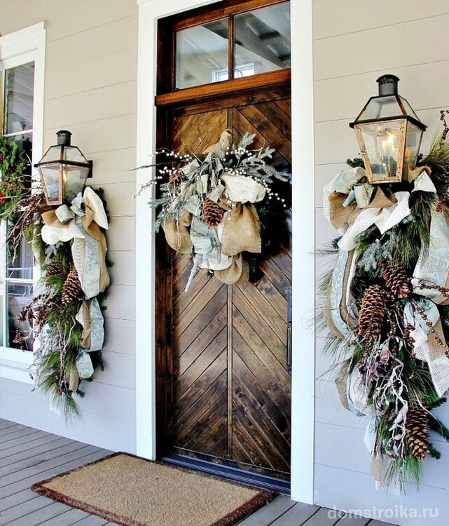 Дверь дома, украшенная традиционным рождественским венком из хвойных ветвей, смотрится очень красиво
