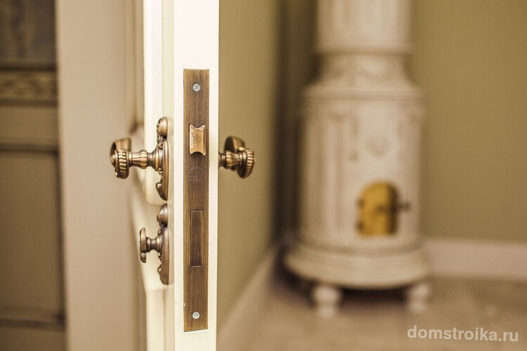 Светлая деревянная дверь с красивой дверной ручкой под бронзу