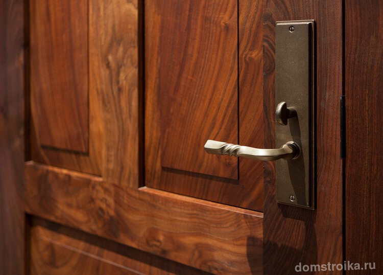 Массивная деревянная дверь соответствующей металлической ручкой и замком