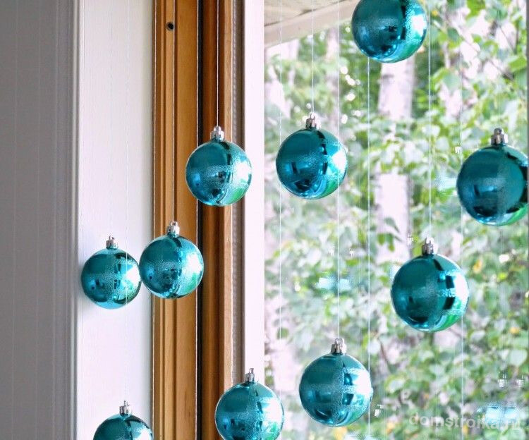 Зона окна, украшенная голубыми елочными игрушками