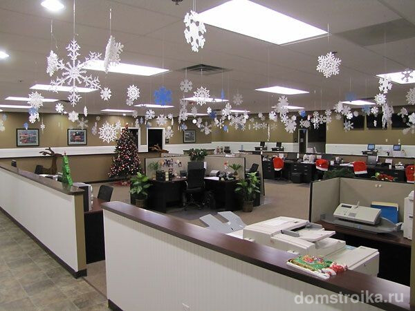 Большой офис, украшенный бумажными снежинками