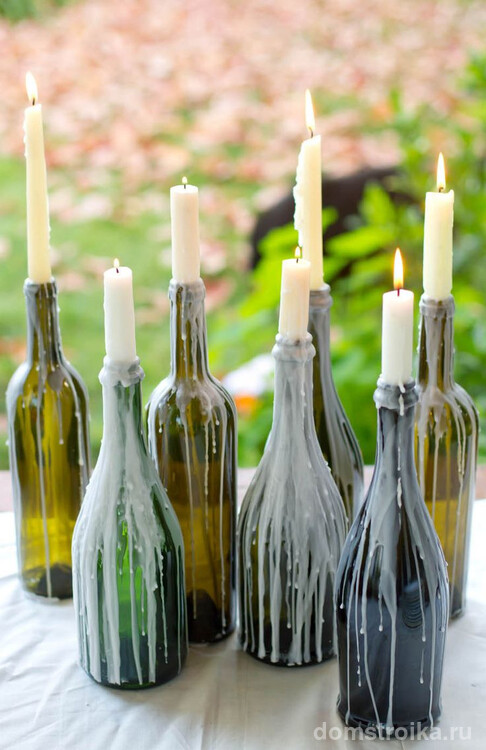 Старые бутылки можно использовать как подсвечник, который сам себя декорирует плавленым парафином