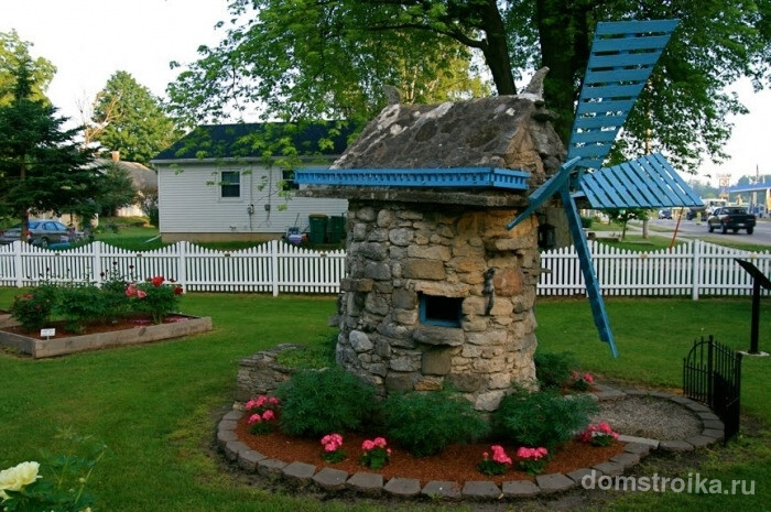 Декоративная мельница, выложенная с камня для хранения садового инвентаря