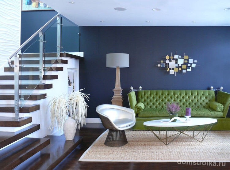 Зеленый диван в гостиной выступает идеальным фоном, который помогает "раскрыться" томным оттенкам стен