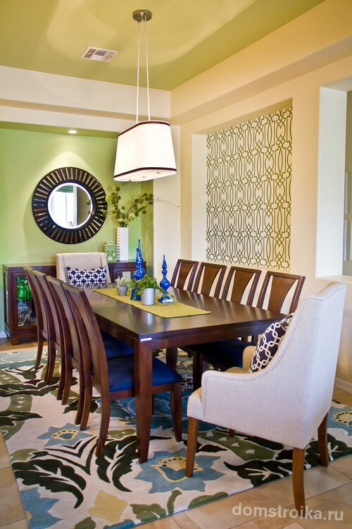 Одна из стен столовой окрашена в светло-салатовый оттенок, вторая имеет сложный повторяющийся геометрический рисунок, а потолок окрашен в теплый зеленый оттенок – оригинальное решение в оформлении современного интерьера