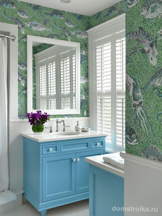 Пляжный стиль ванной комнаты, подчеркивающий обои с эффектом мозаики тематической морской тематики. Мебель и аксессуары имеют бело-синее цветовое решение