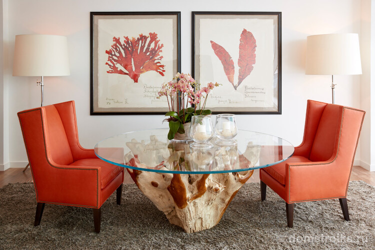 Светлые стены гостиной комнаты, оригинальный стол, строгие кресла с обивкой кораллового цвета - отличное сочетание для яркой и оригинальной гостиной