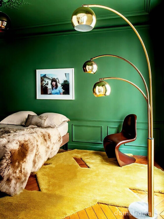 Зеленая спальня вместе с желтым ковром выглядит ярко и контрастно