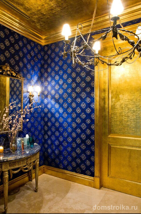 Контрастная гостиная: темные синие обои с принтом и золото в интерьере