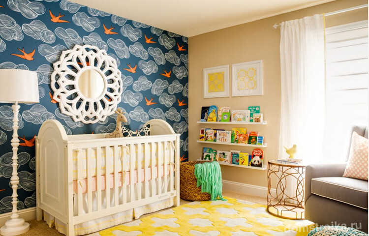 Интересный пейзаж возле детской кроватки: синие обои с тучками, птицами и зеркало в виде солнца