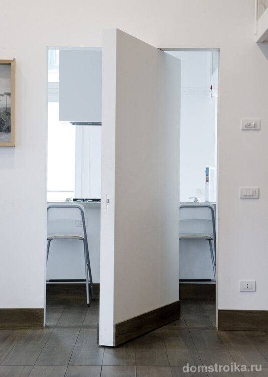 Потайная межкомнатная дверь без ручек в минималистичной тотально белой квартире