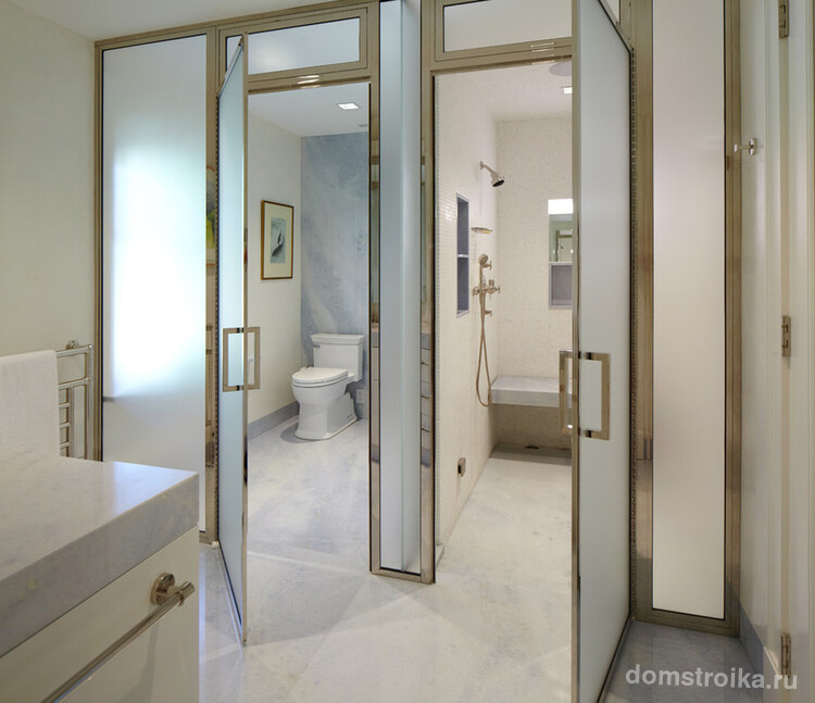 Светлое оформление ванной комнаты небольшого размера с дверями из матового стекла