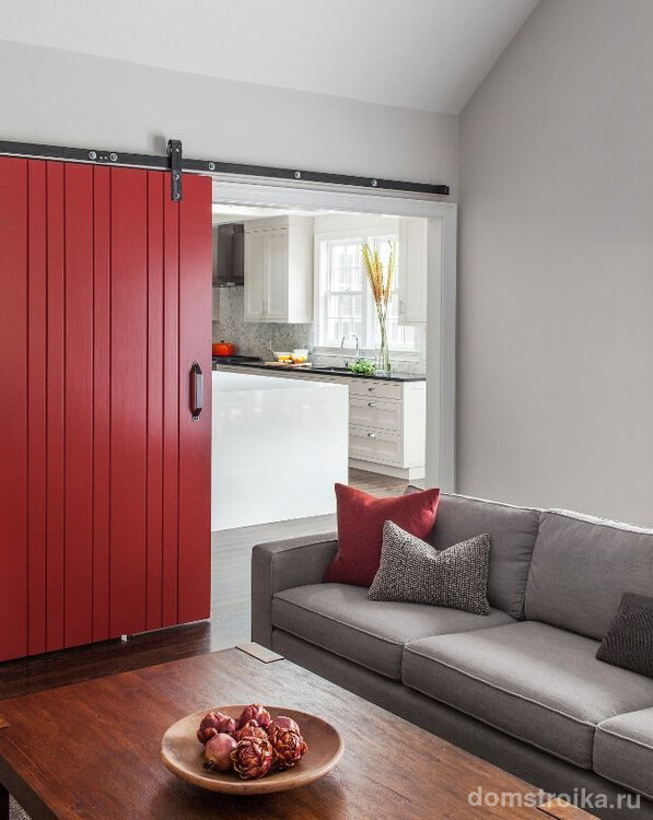 Яркая красная дверь перекликается с цветом диванных подушек