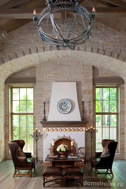 Красивый интерьер гостиной с двумя напольными канделябрами у камина