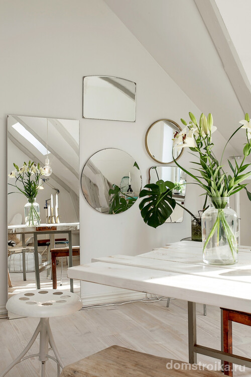 Белые стены можно украсить разными по форме и размеру зеркалами, получившийся “ряд окон” оживляет комнату и делает ее намного светлее