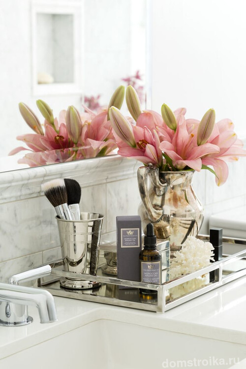 Красивые флакончики с косметикой, букетики цветов чудесно украсят ванную комнату женщины