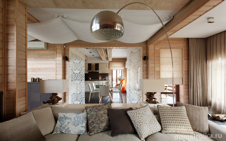 Белый тканевый потолок хорошо смотрится с деревянной отделкой гостиной