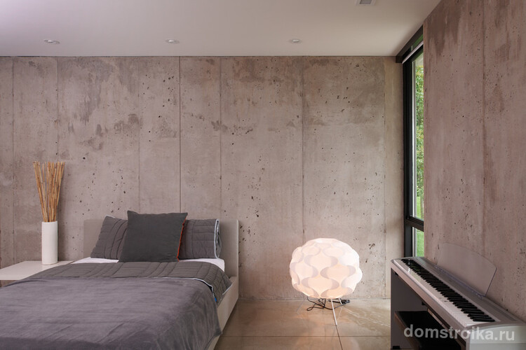 Обои под бетон отлично поддерживают легкую и светлую атмосферу в просторной спальне