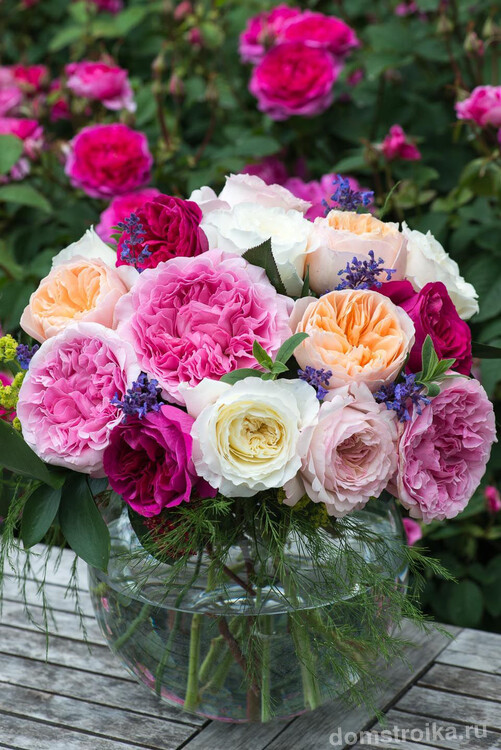 Обыкновенная стеклянная ваза с красивым букетом домашних роз