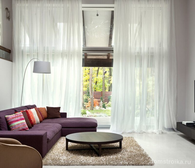 Длиноворсовые ковры контрастного цвета разбавят интерьер просторной гостиной